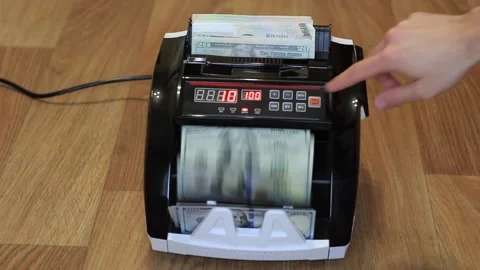 Man's hands put dollars in electronic money counter. electronic money counter Stock Footage 134974122