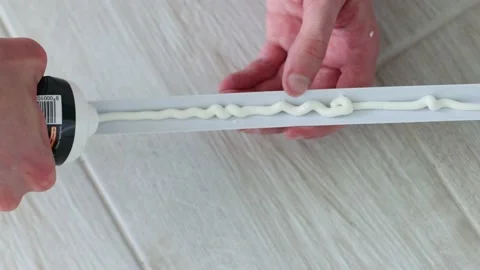 Mans hands putting glue on decorative plastic corner for the wall protection.4K. Stock Footage 200865627