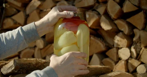 Mans hands putting a jar of bell pepper on a wood storage Stock Footage 128324701