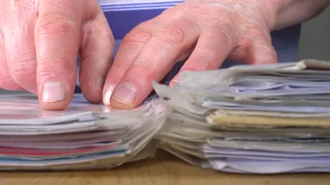 Man’s hands putting paperwork into a ring binder. Stock Footage 131141184
