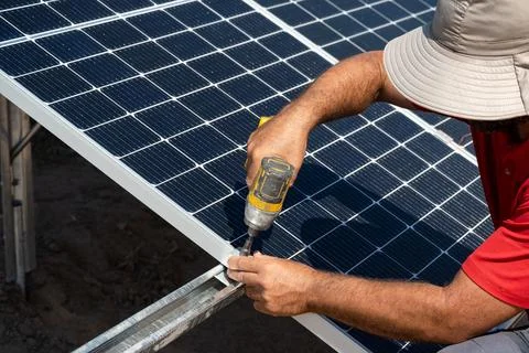 Man's hands putting solar panels, for agricultural irrigation. Stock Photos
