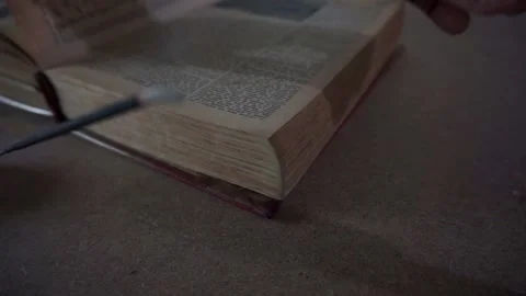 Man's hands reading and leafing through a book, candle and incense, bible Stock Footage 144414933