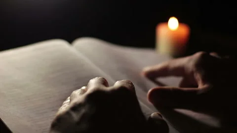 Man's hands reading a book by candlelight 動画素材 102332495