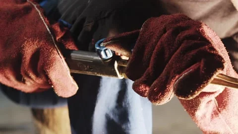 Man's hands in red protective gloves cuts a steel with a hand cutting torch Stockbeeldmateriaal 143663845