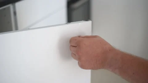 Man's hands remove protective film sticker of furniture piece. Stock Footage 184834730