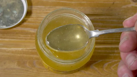 Mans hands removing the lid from a jar of honey then taking a spoonful. Stock Footage 155535951