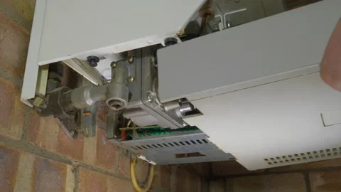 Mans hands removing the lower cover of a domestic gas boiler. Stock Footage 163229907