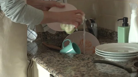 Man's hands rinse plate at the kitchen sink. Stock Footage 196598698