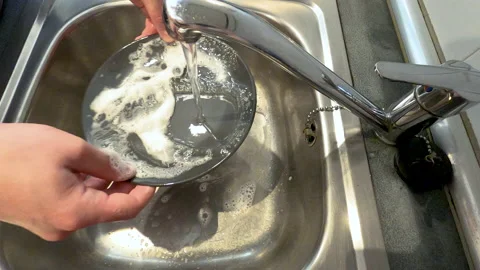 Man's hands rinsing a dish with soap and water in the kitchen Stock Footage 132354937