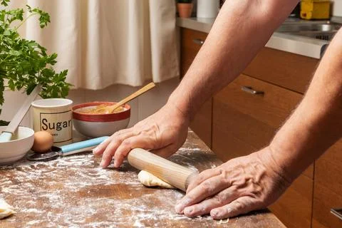 Man's hands with a rolling pin preparing a puff pastry dough in a home kitc.. Stock Photos