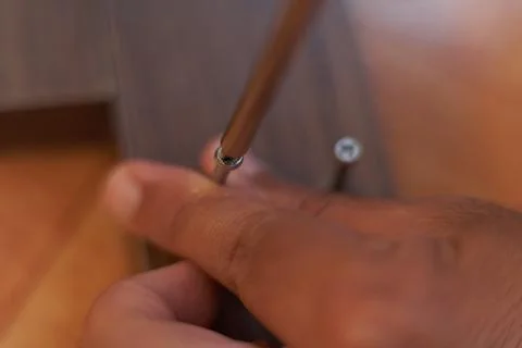 A man's hands screw wood. Assembling furniture at home. Stock Photos