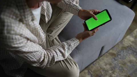 Man's hands scrolling on smartphone with green chroma key on it Stock Footage 231315673