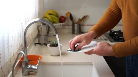 Man's hands scrubbing a plate in the kitchen Stock Footage 149397603