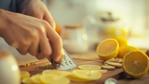 A mans hands skillfully grate fresh ginger filling the air with a pungent ar Stock Footage 331314311