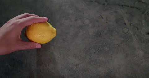 Man's hands slices down a lemon on the table Video stock 238775419