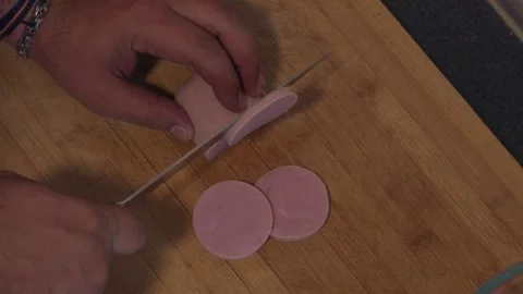 Man's hands slicing boiled sausage on wooden cutting board Stock Footage 337622343