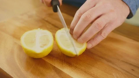 Man's Hands Slicing Lemon With Knife On Chopping Board Stock Footage 86069931
