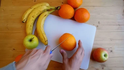 Man's Hands Slicing Orange With Knife On Chopping Board Stock Footage 106289756