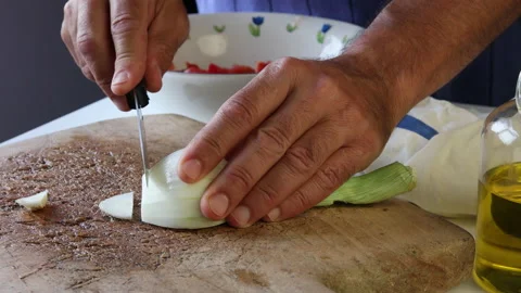 Man's hands slicing a spring onion on a wooden board. Stock Footage 195950076