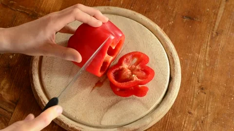 Man's hands slicing sweet Red Bell Pepper on a wooden cutting board. Stock Footage 58891476