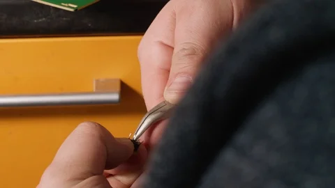 Man's hands solder button to electrical card. Close up view of man's hands Stock Footage 108106653