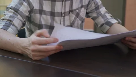 Mans hands sort out sheets with drawings in business office. No face. Video stock 76804758