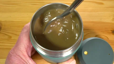 Man's hands stirring hot tea or coffee in insulated cup, then screwing on lid. Vídeos de archivo 170257568