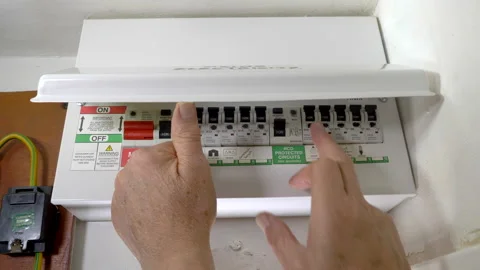 Man's hands switching off a power circuit in a mains electricity fuse box. Stock Footage 158575329