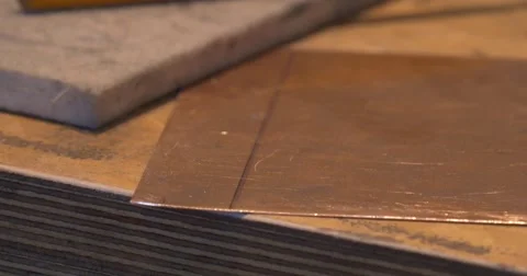 Man's Hands Take The Square Piece of Copper Plate Start to Grind the Edges Stock Footage 53432789