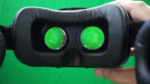 Mans hands take VR glasses wear them at geen background. Stock Footage 168975941