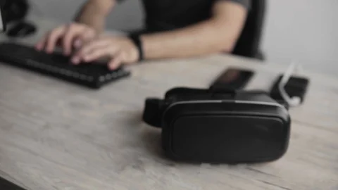 Mans hands take a VR headset for using. Virtual reality glasses laying on a Stock Footage 122110152