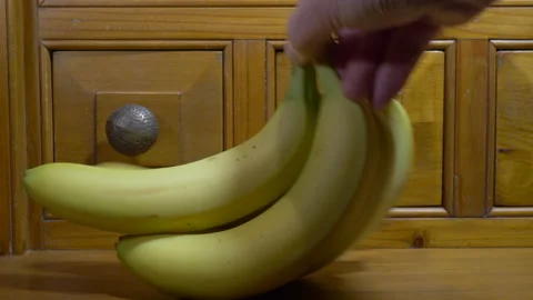 A man’s hands taking a bunch of bananas from a packet. Stock Footage 145264909