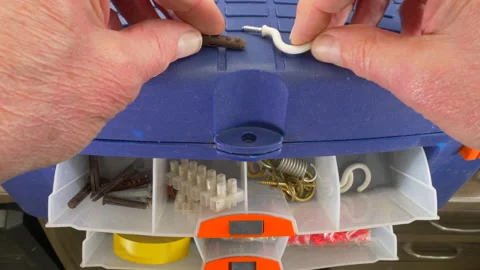 Mans hands taking a hook and wallplug from drawers in a toolbox. Video stock 154735312