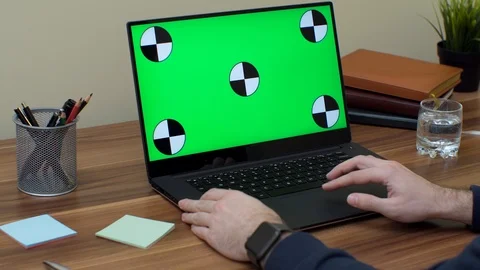 Man's hands taping and scrolling on the laptop computer with green screen Stock Footage 87571948