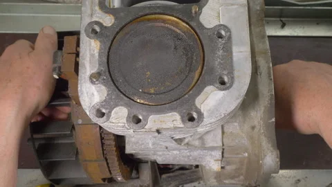Man's hands testing the piston movement in a machine engine block. Video stock 159140711