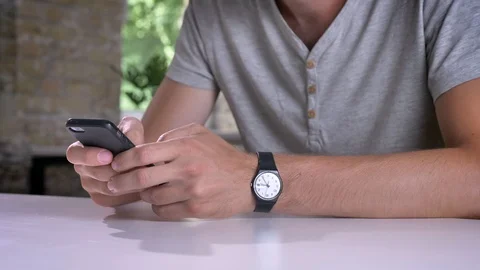 Man's hands texting on mobile phone, sitting at table in modern office Video stock 92665297