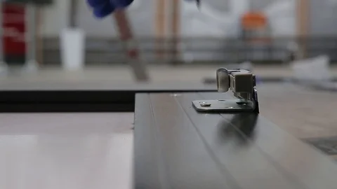 Mans hands tighten screw during assembling furniture doors system. Close up view Stock Footage 122855237