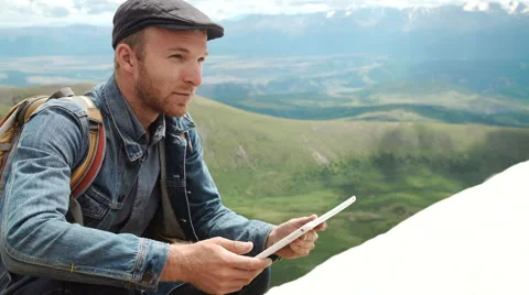 Man's hands touching screen of digital tablet on the background of mountains Stock Footage 65308485
