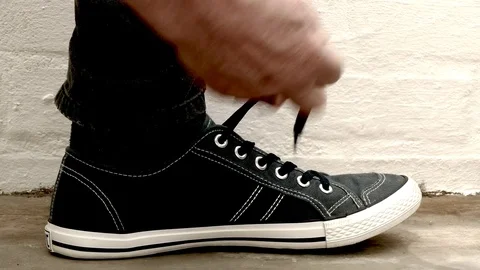 Man’s hands tying a shoelace. Video stock 77635532