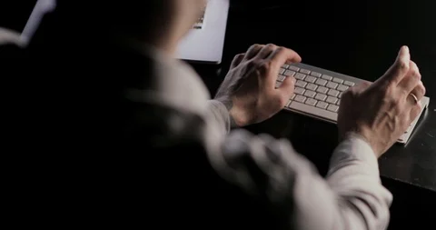 Man's hands typing on the keyboard sitting at the table on workplace. Video stock 105302528