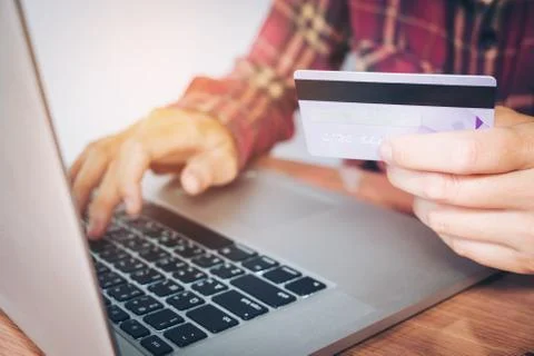 Man's hands typing laptop keyboard and holding credit card online shopping .. Stock Photos