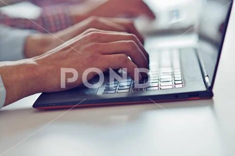 Man's hands typing on laptop keyboard Stock Photos