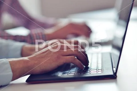 Man's hands typing on laptop keyboard Stock Photos