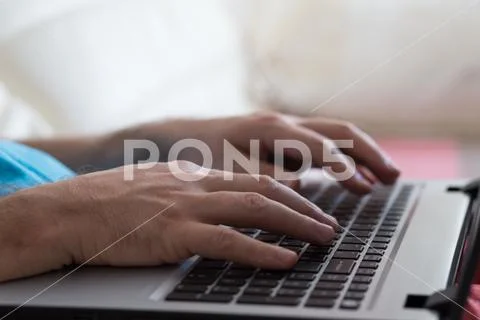 Man's hands typing on laptop notebook keyboard at home. Man browsing information Stock Photos