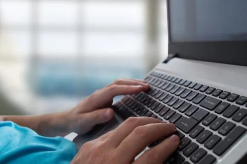 Man's hands typing on laptop notebook keyboard in the office. Man browsing Foto stock