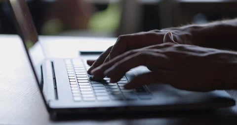 Man's hands typing text on laptop keyboard at wooden desk.Guy using online Stock Footage 164172105