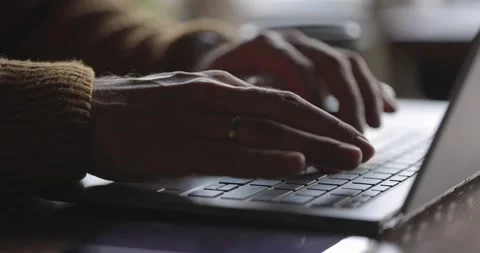 Man's hands typing text on laptop keyboard at wooden desk.Guy using online Stock Footage 164674706