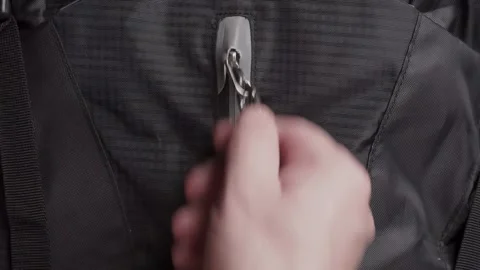 Man's hands unzip and zip up a backpack Stock Footage 284745613