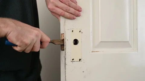 Man's hands use rusty chisel for door lock hole Stock Footage 166113939