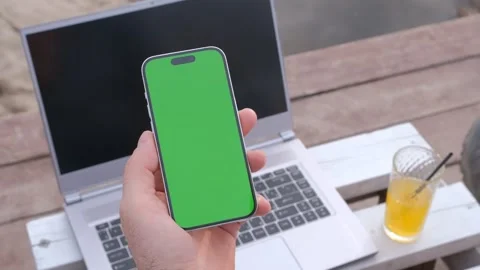 Man's hands use smartphone with laptop, money dollars on the beach closeup, top Stock Footage 246469252